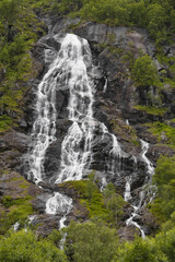 Obraz premium A beautiful waterfall in the forest with several smaller streams flowing over the rocks.