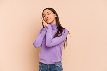 Young colombian woman isolated on beige background yawning showing a tired gesture covering mouth...