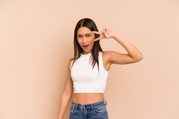 Young colombian woman isolated on beige background dancing and having fun.