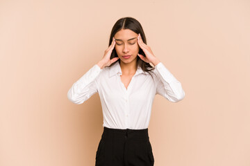 Young colombian woman isolated on beige background having a head ache, touching front of the face.