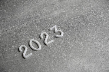 Year 2023 laid out in white numbers gray concrete background.