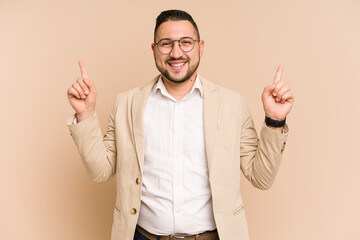 Adult latin business man cut out isolated indicates with both fore fingers up showing a blank space.