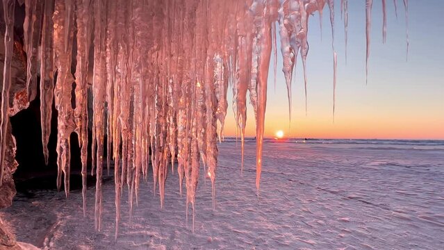 Frozen winter lake Baikal, Siberia, Russia. Ice icicles and blocks in the rocks, grottoes and caves at dawn. Natural background of cold ice. Winter abstract background. High quality 4k footage