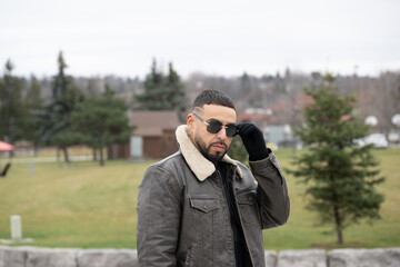 Black model with fancy hair cut and sunshades on in the cold 