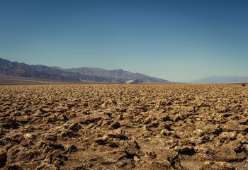 Wrinkle, dry ground Badwater basin with mountains backround in Death Valley national park