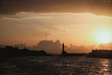 Chania, Greece, view of the old venetian lighthouse in the city harbour at sunset. 