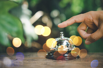 Hospitality hotel. Customer hand ringing service bell at coffee cafe shop for calling the staff to receive the menu, Woman finger touching to ring bell