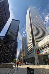 Fototapeta na wymiar Toronto, Canada, Aug 5, 2022. Humans appear tiny before these tall commercial towers.