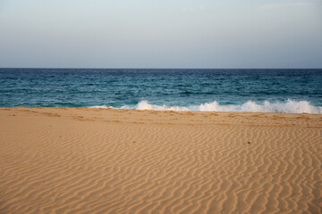 Sand on a beach on the atlantic ocean with a blurred water in the background.