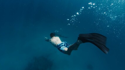 Obraz na płótnie Canvas Man dives in a tropical sea in the Maldives