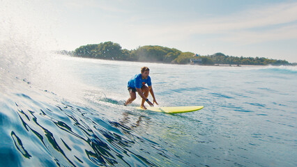 Surfer rides the ocean wave in the Maldives