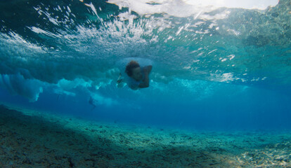 Boy surfer falls into the water during surfing