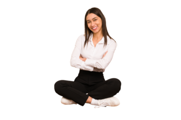 Young colombian woman sitting on the floor isolated smiling confident with crossed arms.