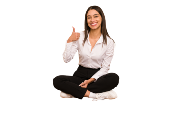 Young colombian woman sitting on the floor isolated smiling and raising thumb up