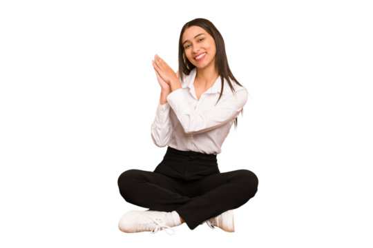 Young colombian woman sitting on the floor isolated feeling energetic and comfortable, rubbing hands confident.