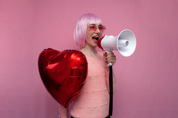 girl with pink hair holds an inflatable heart balloon and screams loudly on a pink background,...