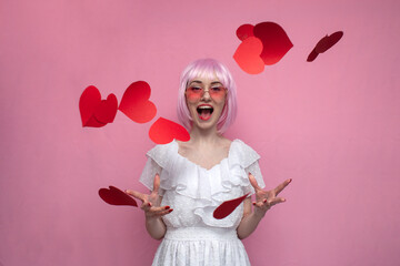 girl with pink hair in a dress screams and throws confetti on a pink background, a woman with...