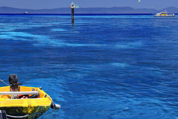 Yellow dinghy-starboard beacon-tourist pontoon-hydrographic survey vessel seen from Green Island...