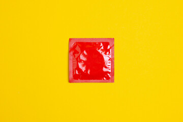condom lie on a yellow background, the concept of safe sex