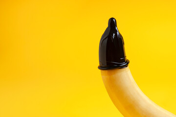 condom dressed on a banana on a yellow background, erection concept, safe sex concept, sexual male...