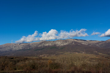 Stunning landscape view of Suva Planina, featuring the entire mountain and the surrounding autumn forest on a sunny day