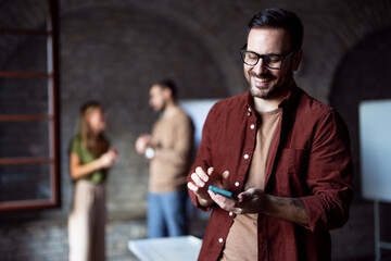 Smiling handsome businessman talking on the phone at business conference