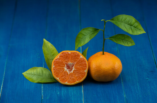 Close-up footage of orange and tangerine fruit on blue background.