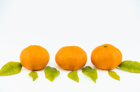Close-up footage of orange and tangerine fruit on white background.