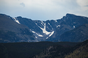 Snowy mountains surrounded by trees and rolling hills in Rocky Mountain National Park 