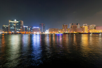 Fototapeta na wymiar Dubai Creek skyline illuminated at night in Dubai, United Arab Emirates.