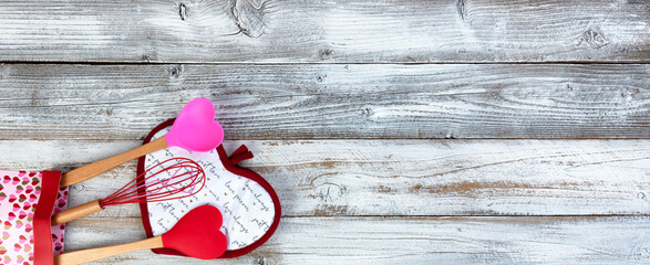 Pot holder heart pattern with kitchen utensils on white wood background for a happy Valentines day setting