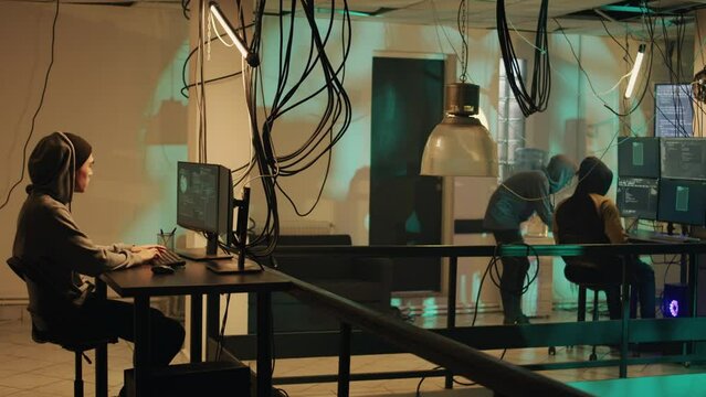 Cyber criminal committing cryptojacking and espionage crime, planting network malware and trojan virus to break into server. Young male spy practicing cyberbullying and doing illegal activity.