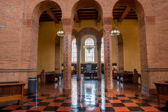 Los Angeles, USA. September 20, 2022. Chandeliers hanging on ceiling over tiled floor seen through patterned columns and arches inside the UCLA