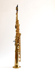 Soprano Sax, wind instrument saxophone staying on a white background, vertical, copy space