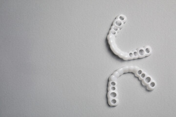 Dental mouth guards on light grey background, flat lay with space for text. Bite correction