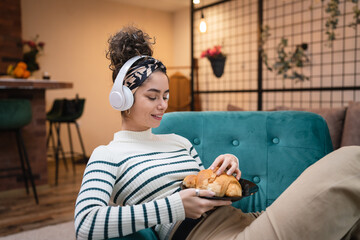 Fototapeta premium one woman having homemade baked croissant for breakfast at home