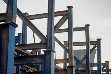 Massive steel scaffolding supports the concrete bridge structure that creates a way around the city highway.