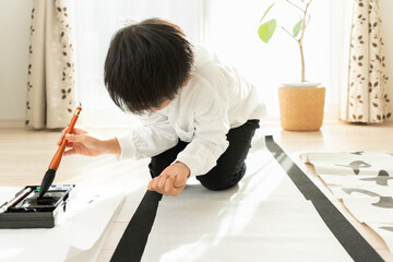書き初めを書く日本人の小学生の男の子