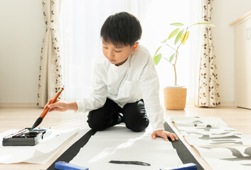書き初めを書く日本人の小学生の男の子 - obrazy, fototapety, plakaty
