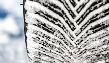 Closeup selective focus on snow packed in an all-weather tire tread.