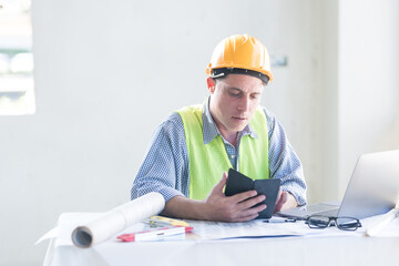 Architect concept, Architects working with blueprints in the office Business accessories (laptop, smartphone, pens, magnifier), accessories for drawing (plans, rulers) and learning on the table