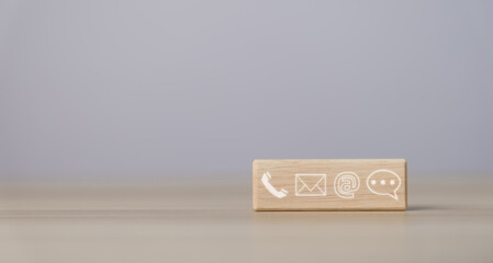 wood block cube showing icons of phone, email, address, and live chat. Contact us about the concept...