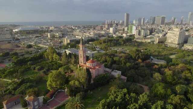 Saint Peter and Saint Tabitha Russian Orthodox Church in Tel Aviv at sunset surrounded by trees and lawns - parallax shot