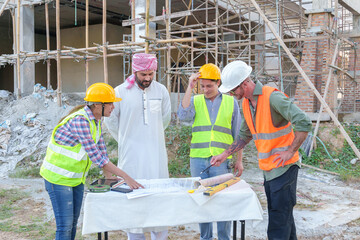 Diverse team of professionals using tablet computers on construction site. Real estate construction project. with civil engineers, architects, Arabic business investors and explorer with theodolite