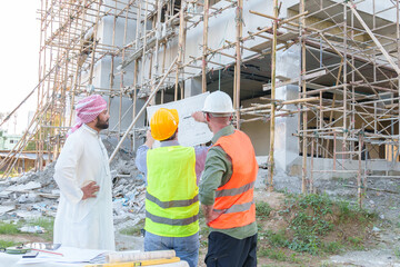 Diverse team of professionals using tablet computers on construction site. Real estate construction project. with civil engineers, architects, Arabic business investors and explorer with theodolite