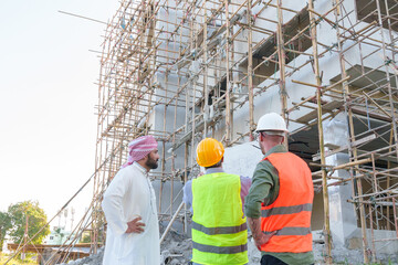 Diverse team of professionals using tablet computers on construction site. Real estate construction project. with civil engineers, architects, Arabic business investors and explorer with theodolite