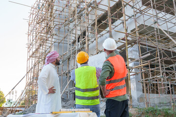 Diverse team of professionals using tablet computers on construction site. Real estate construction project. with civil engineers, architects, Arabic business investors and explorer with theodolite