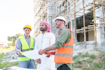 Diverse team of professionals using tablet computers on construction site. Real estate construction project. with civil engineers, architects, Arabic business investors and explorer with theodolite