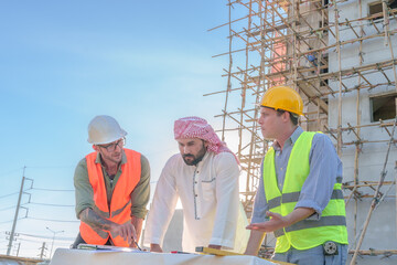 Diverse team of professionals using tablet computers on construction site. Real estate construction project. with civil engineers, architects, Arabic business investors and explorer with theodolite