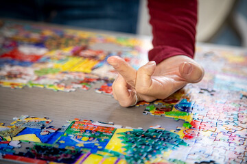 Closeup of hands working a puzzle